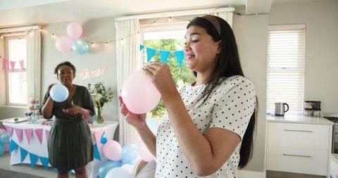 Friends preparing baby shower celebration decorating with balloons