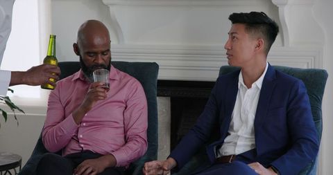 Multicultural friends enjoying drinks at home