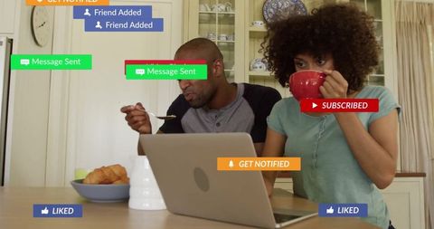 Couple browsing and engaging with notifications at kitchen table