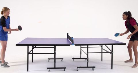 Diverse Women Competing in Ping Pong Match