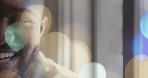 Smiling man left profile close-up, bokeh lights, vertical blinds, warm soft-light headshot