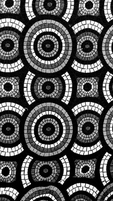 This intricate mosaic pattern features repeating circles in a black and white geometric design, making it perfect for use in textile design, wallpaper, backgrounds, or digital art projects. The continuous nature of the pattern allows for seamless application in various creative projects.