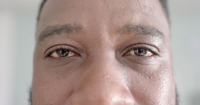 Unaltered portrait of happy african american male doctor opening eyes and looking at camera. Healthcare, medicine and hospital.