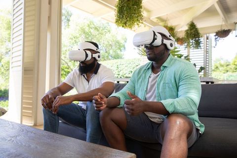 Male Friends Enjoying Virtual Reality Together Outdoors