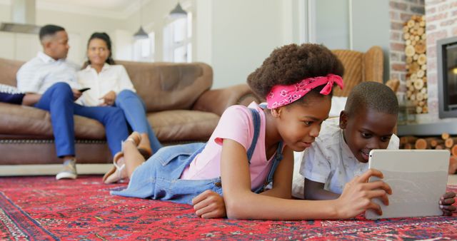 Children Using Tablet on Rug While Parents Relax on Sofa - Download Free Stock Images Pikwizard.com