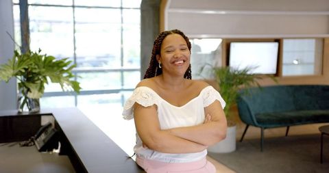 Confident Woman Smiling in Contemporary Office Lobby