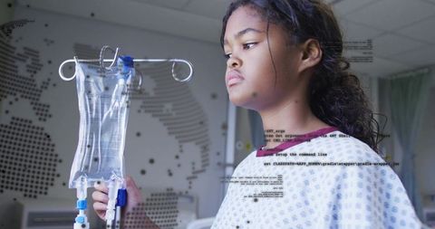 Young girl holding iv bag examining tubing in pediatric hospital room with medical monitor