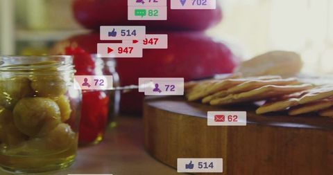 Sunlit rustic cracker platter with olives, jam and apples with floating social media notifications