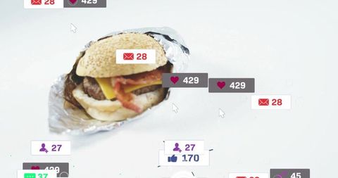 Sitting partially unwrapped cheeseburger with social media notification badges