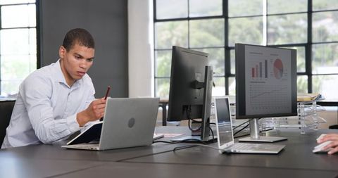 Focused Business Analyst Working in Modern Office on Laptops and Monitors