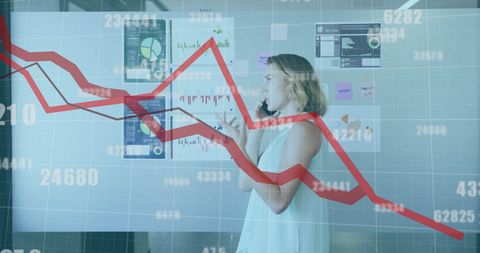 Businesswoman analyzing financial graphs with data overlay
