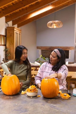 Family pumpkin carving activity in rustic dining area