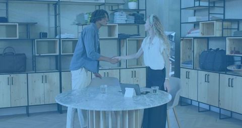 Retail Professionals Shaking Hands in Modern Showroom Around Marble Table