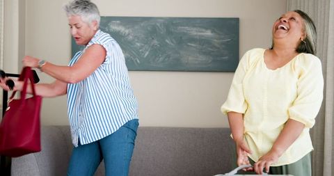 Joyful Senior Lesbian Couple Preparing for Vacation Together