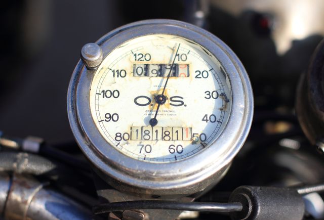Vintage motorcycle speedometer displays mileage and kilometers per hour. Ideal for illustrating concepts of age, retro transportation, mechanics, history, and antique vehicles. Suitable for articles, blogs, advertisements, and educational materials about vintage motorcycles and mechanical instruments.