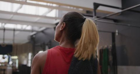 African American Woman Resting in Gym with Towel Over Shoulder