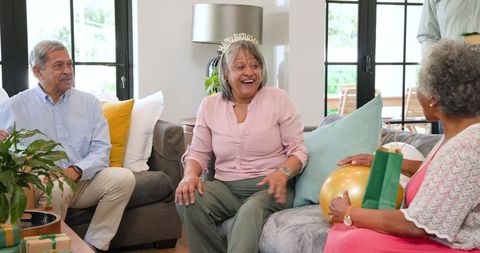 Senior Friends Celebrating Birthday with Gifts and Laughter