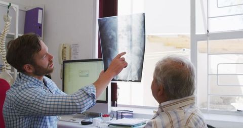 Doctor Discussing X-ray with Senior Patient in Office