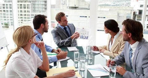 Business team analyzing financial chart in meeting room