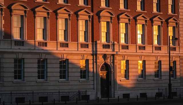 Historic georgian brick and stone facade glowing in golden hour light with ornate doorway
