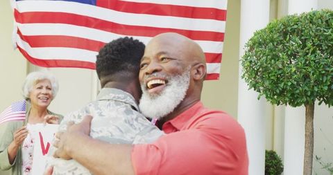 Returning Soldier Embraced by Family Amidst Patriotic Celebration