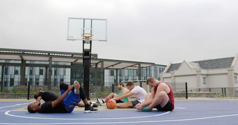 Diverse Basketball Team Stretching on Outdoor Court