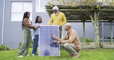 African american family learning about residential solar panel installation in backyard