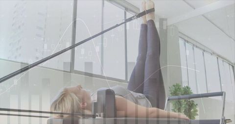 Woman Exercising on Pilates Reformer in Modern Fitness Studio