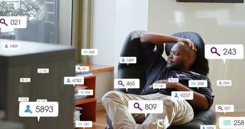 Man Surrounded by Social Media Notifications Icons Relaxing at Home