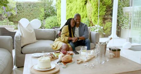 Joyful Couple Celebrating with Cake in Sunny Outdoor Setting