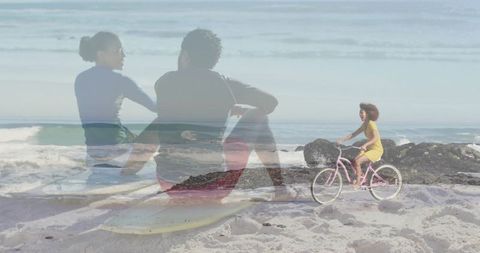 Cycling on beach with shadows of surfing couple