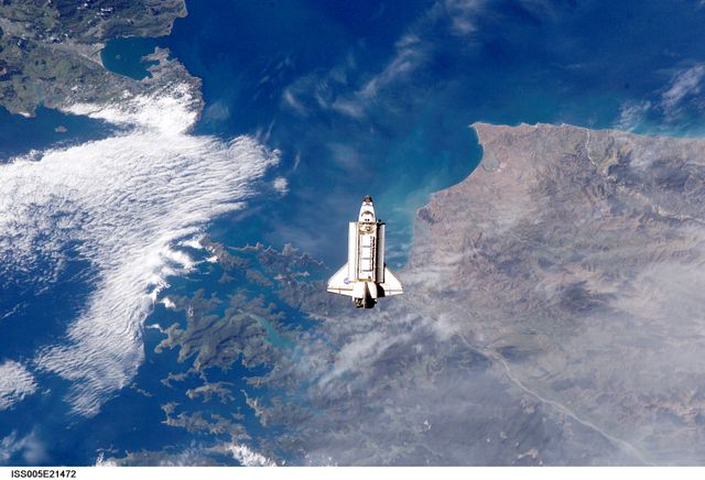 ISS005-E-21472 (25 November 2002) --- The Space Shuttle Endeavour is backdropped over Cook Strait, New Zealand as it approaches the International Space Station (ISS) during STS-113 rendezvous and docking operations. Docking occurred at 3:59 p.m. (CST) on November 25, 2002. The Port One (P1) truss, which was later to be attached to the station and outfitted during three spacewalks, can be seen in Endeavour's cargo bay. Endeavour's namesake, and her captain, First Lieutenant James Cook,  moved through the waters of Cook Strait for the first time on Feb. 7, 1770.