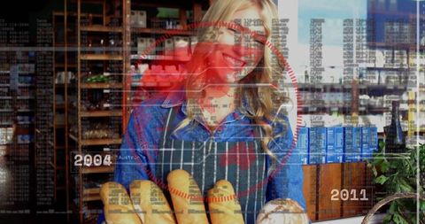 Smiling baker arranging artisanal baguettes at rustic bakery counter with red hud overlay