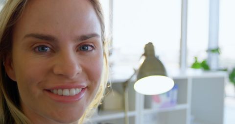 Caucasian Female Fashion Designer Smiling in Modern Office Environment