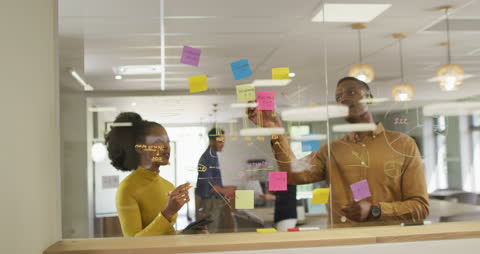 Diverse Team Collaborating on Office Glass Board with Ideas