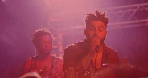 Soulful Live Performance in Vibrant Red Lighting at a Concert