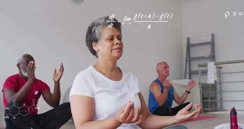 Mature adults meditating in group yoga practicing mindfulness, breathwork and calm focus