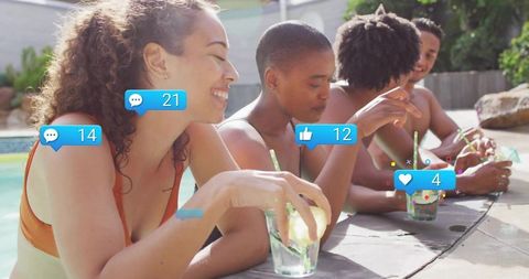 Friends relaxing by poolside sipping cocktails and sharing social media reactions