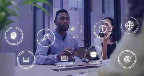 Presenting man discussing tablet data during collaborative meeting with digital icons
