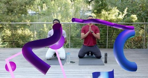 Two men kneeling and praying on sunlit deck for outdoor yoga with bold 3d ribbons