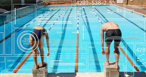 Competitive swimmers leaning on starting blocks preparing to dive at sunlit outdoor pool