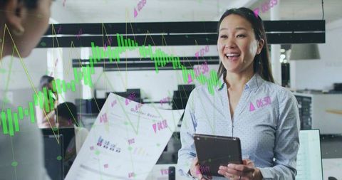 Smiling businesswoman discusses financial charts with colleague