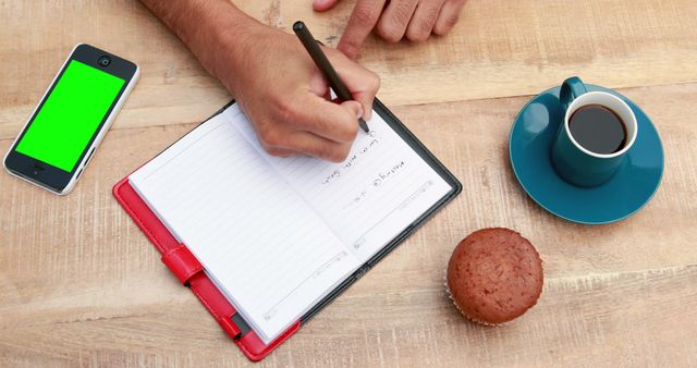 Writing Notes in Planner with Coffee, Smartphone, and Muffin on Table - Download Free Stock Images Pikwizard.com