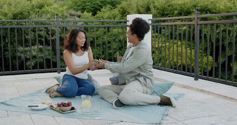 Couple Enjoying Romantic Gift Exchange During Outdoor Picnic