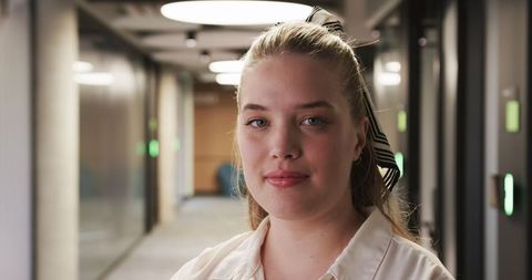 Confident Female Professional in Modern Office Corridor