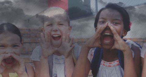 Joyful Schoolchildren Carrying Backpacks and Enjoying Rain