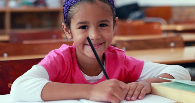 Smiling Girl Writing at School Desk - Download Free Stock Images Pikwizard.com