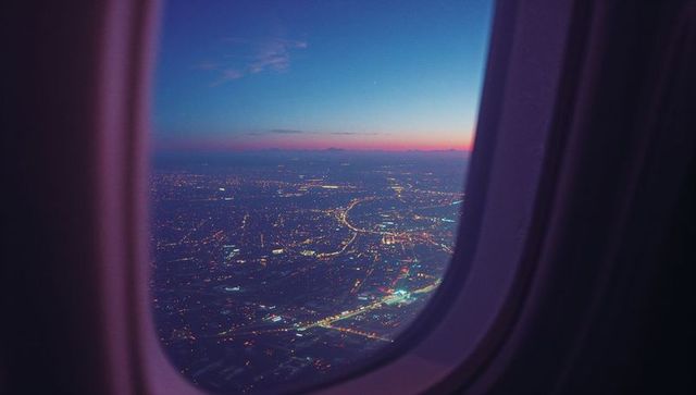 Aerial Cityscape and Sunset Horizon from Airplane Window
