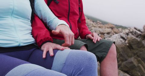 Senior Hiking Couple Holding Hands on Rocky Coastline Adventure