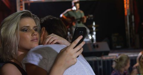 Young People Embracing and Taking Selfie at Energetic Live Concert